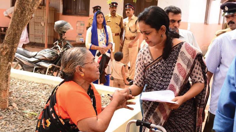 Alappuzha collector Veena N Madhavan talks to handicapped woman outside the Sevana Sparsham venue on Saturday. (Photo: DC)