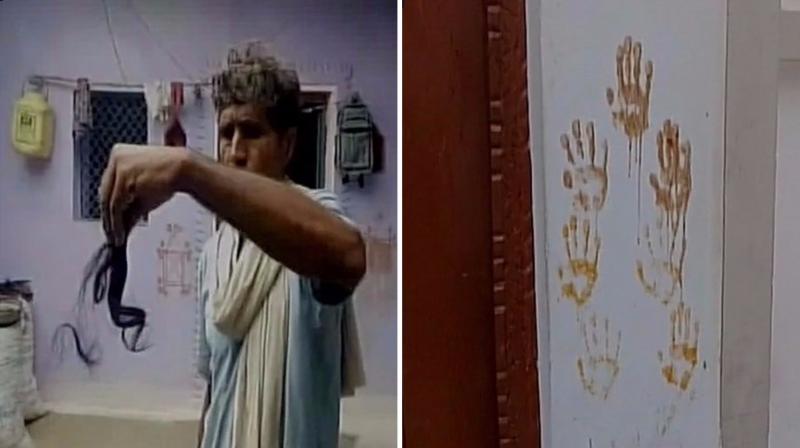 Most villagers have covered the outside walls of their homes with henna handprints, along with the lime, chillies and neem leaves to ward off evil spirits. (Photo: ANI/Twitter)