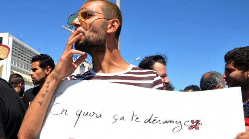 One man openly smoking a cigarette -- this is also deemed unacceptable during Ramadan daylight hours -- held a placard in French that asked: \Why does it bother you if you fast and I eat?\ (Photo: AFP)