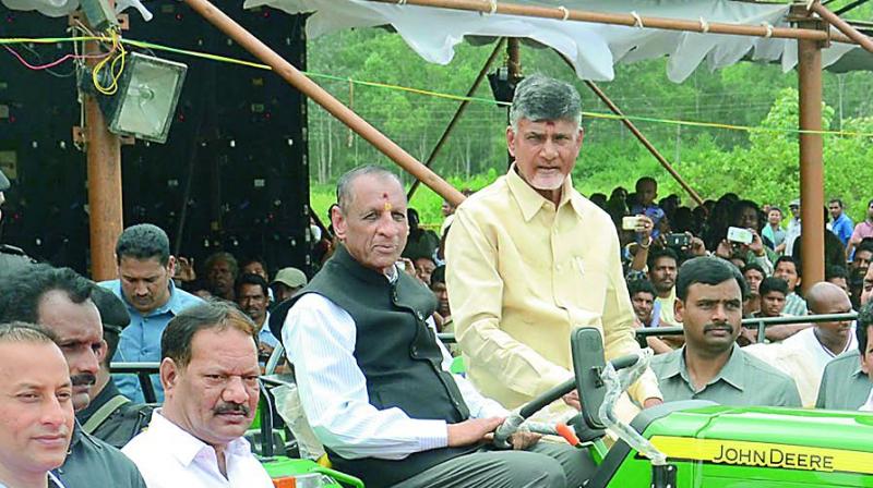 Governor E.S.L. Narasimhan and Chief Minister N. Chandrababu Naidu sit on a tractor after inauguration of the tractors during a meeting to mark the International Day of Worlds Indigenous People celebrations at Araku in Visakhapatnam Agency on Wednesday. (Photo: DC)