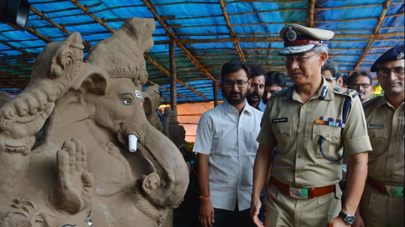 Commissioner of Police D. Gautam Sawang takes a look at the clay Ganesh idols made by Paryavarana Parirakshna Samiti in Vijayawada on Wednesday. (Photo: DC)