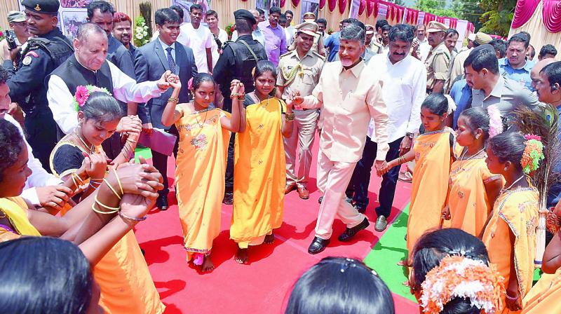 Chief Minister N. Chandrababu Naidu along with the Governor E.S.L. Narasimhan performs the Dhimsa Dance with tribal youngsters to mark Tribal Day at Araku in Visakhapatnam agency on Wednesday. (Photo: DC)