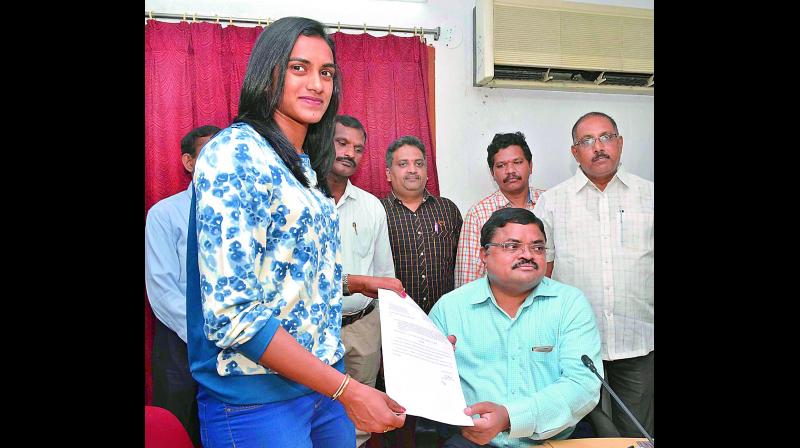 Shuttler P.V. Sindhu receiving orders from secretary to CCLA and joint commissioner G. Rama Rao at Gollapudi near Vijayawada on Wednesday. (Photo: DC)