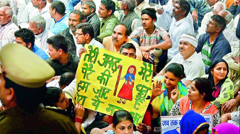 Members from Jat Community display a poster during a rally organised by All India Jat Aarakshan Sangarash Samiti at Jantar Mantar in New Delhi on Thursday. (Photo: PTI)