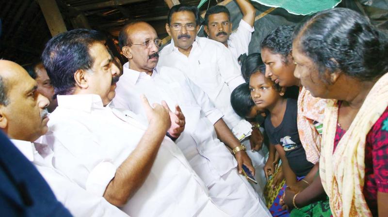 Opposition leader Ramesh Chennithala interacts with family members of farm workers who died due to exposure to pesticides, in Vengala on Monday.