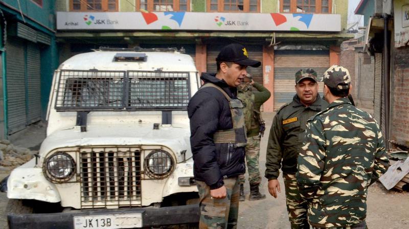 Senior Police and Army officers inspecting Outside Jammu and Kashmir Bank which was looted by unknown gunmen,at Arihal in Pulwama district of south Kashmir. (Photo: PTI)