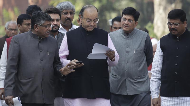 Finance Minister, Arun Jaitley, reads a note while walking towards the Parliament. (Photo: AP)