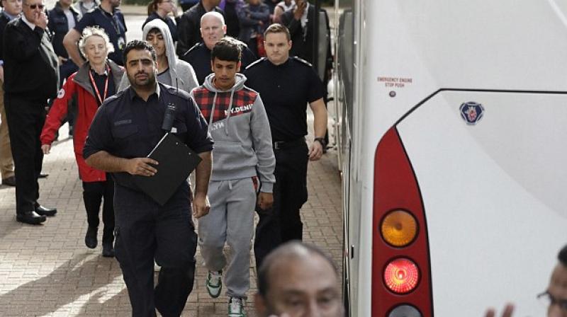 Young migrants get off a bus as they arrive at Lunar House, which houses the headquarters of UK Visas and Immigration, in Croydon. (Photo: AP)