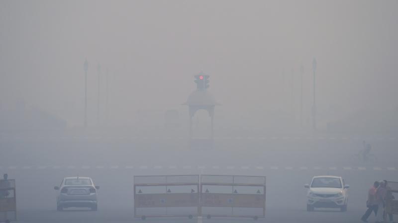 Vehicles ply at Rajpath as smog covers it in New Delhi. (Photo: PTI)