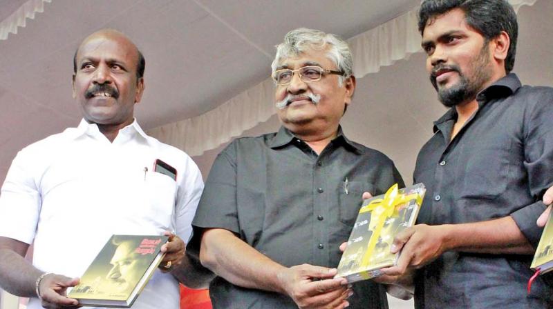 Film director Pa Ranjith receives the first copy of the book from professor Su Ba Veerapandian on Monday at Chennai book fair. Author M. Subramanian also seen. (Photo: DC)