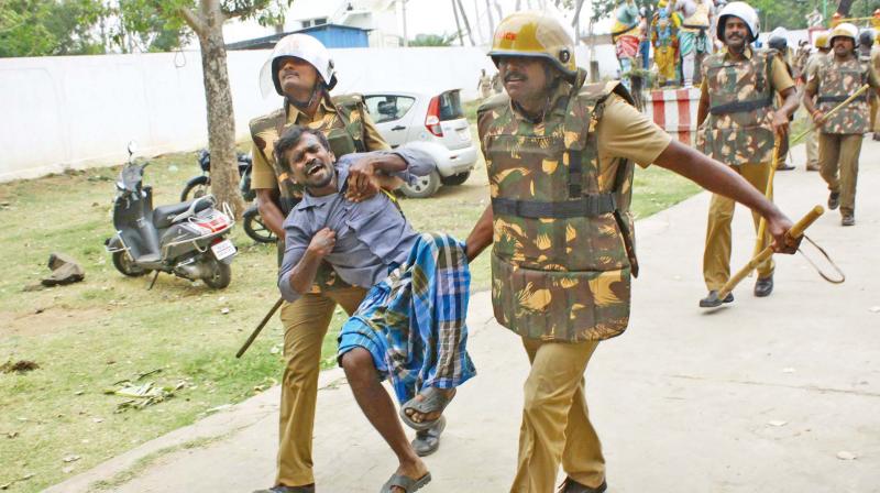 Cops remove a man protesting against jallikattu ban (Photo: DC)