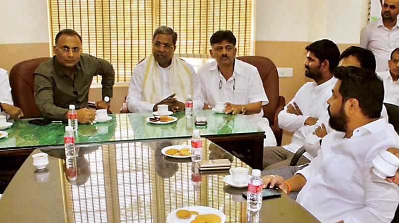 Senior Congress leaders Dinesh Gundurao, Siddaramaiah and D.K. Shivakumar at a party meeting in Bengaluru on Friday