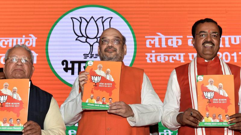 BJP President Amit Shah with UP BJP chief Keshav Prasad Maurya releasing party manifesto for the upcoming Uttar Pradesh assembly elections in Lucknow. (Photo: PTI)