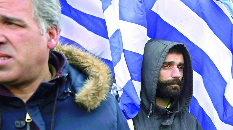 A farmers holds a Greek flag during a protest in Athens against increases in their taxation and pension contributions, as part of Greeces bailout obligations. (Photo: AP)