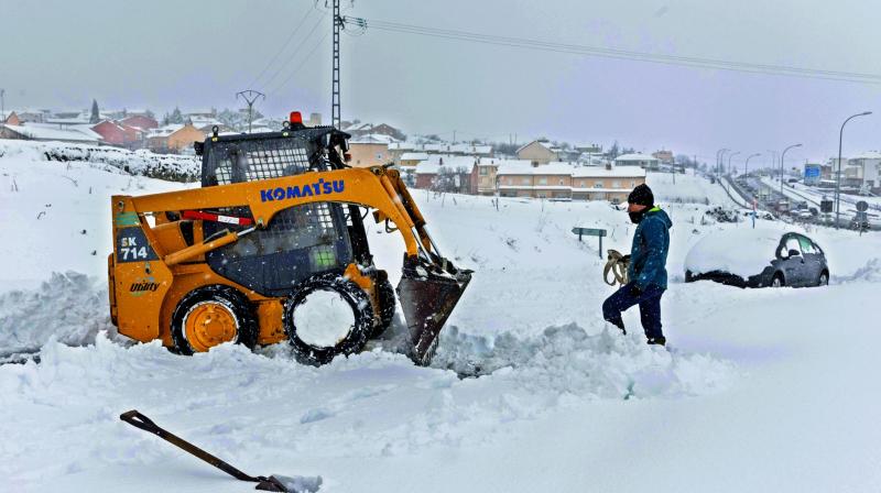 A small bulldozer clears a road at the entrance of Villacastin, Segovia province, after the winters first heavy snowfall