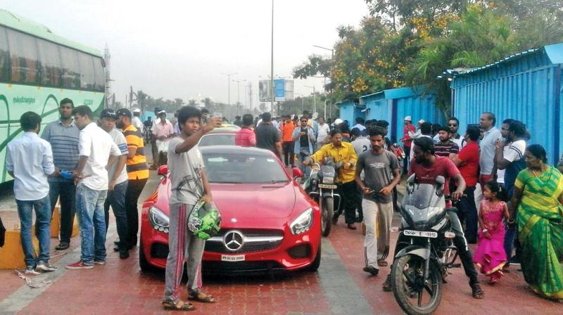 Youths take selfies with a line of cars near Uthandi toll gate on Sunday. (Photo: DC)