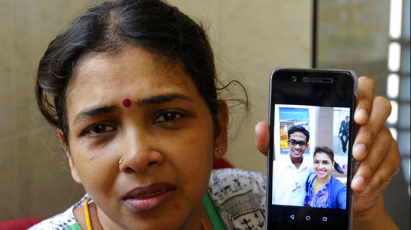 An unidentified relative of Malaysian teenager T Nhaveen shows a picture with the teenager, outside Penang Island General Hospital in Penang (Photo: AP)