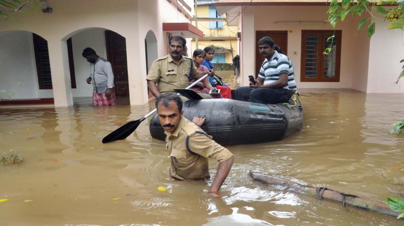Fire and Rescue Services Department officials from Eloor Fire Station engaged in rescuing flood-hit people in Bosco Colony near Eloor. (Photo: DC)