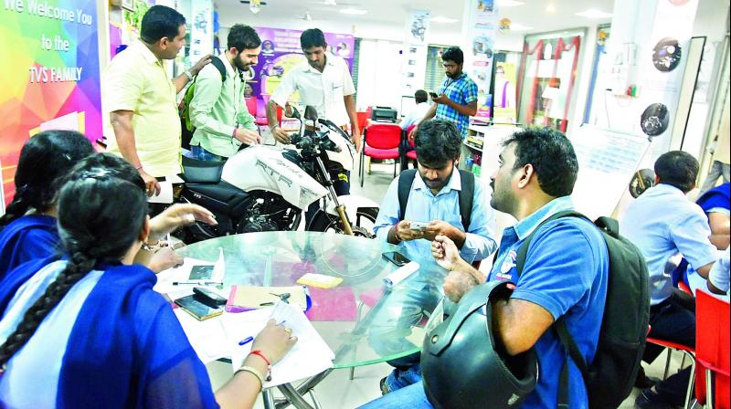 Customers purchasing two-wheelers at the TVS showroom in Kukatpally at 10 pm on Thursday.  (Photo: DC)