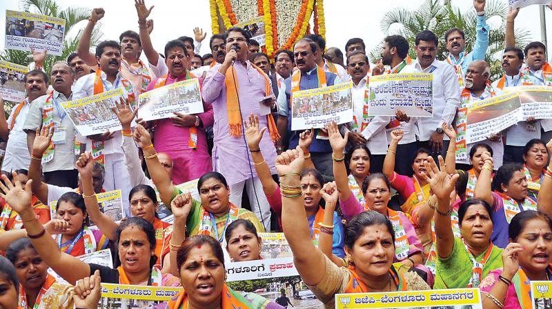 BJP workers led by party leader R. Ashok protest in Bengaluru on Thursday against the BBMP for potholes and bad roads in the city  (Photo: DC)