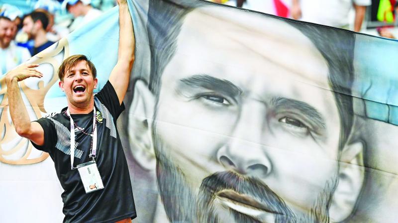 A fan holds a flag with a painting that resembles Lionel Messi at the Kazan Arena on Saturday. (Photo: AP)