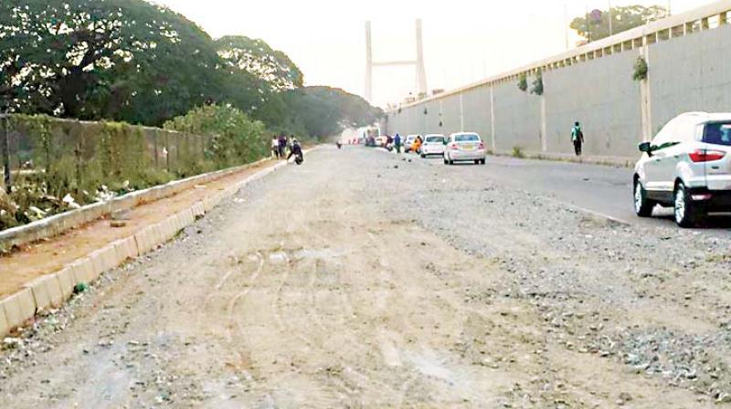 The service road next to the KR Puram cable-stayed bridge, which connects to Whitefield via underpass, is in a complete mess, where only half the road is asphalted, while the other half is covered with crushed stones.