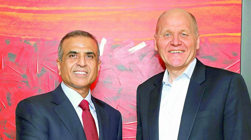 Bharti Enterprises founder and chairman Sunil Bharti Mittal shakes hands with Telenor Group CEO Sigve Brekke after the announcement of Airtels acquisition of Telenor (India) in New Delhi on Thursday. (Photo: PTI)