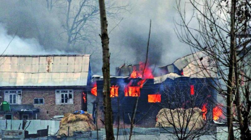 A house in which militants are suspected to have sheltered is in flames after a gunfight between militants and the security forces in South Kashmirs Pulwama district, some 10 km away from the spot of the recent suicide bombing. (Photo; AFP)