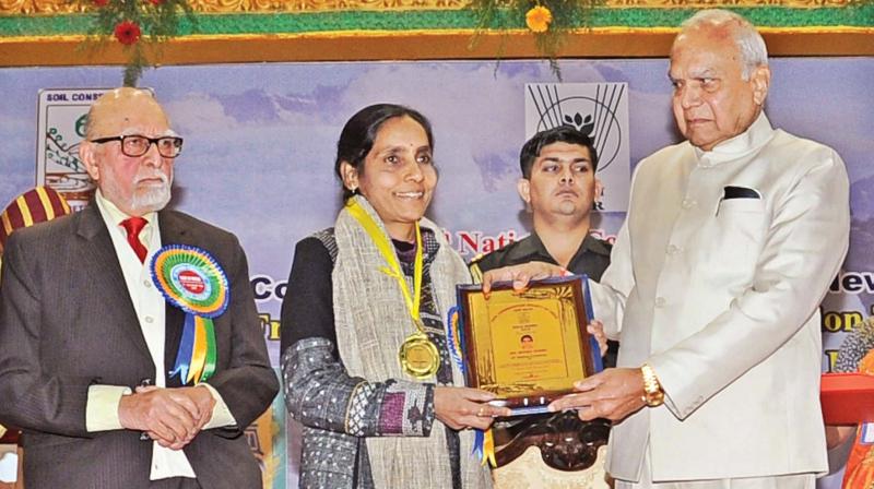 Governor Banwarilal Purohit distributes award to one of the scientists who contributed in the field of research on soil and water conservation in Ooty on Thursday.	(DC)