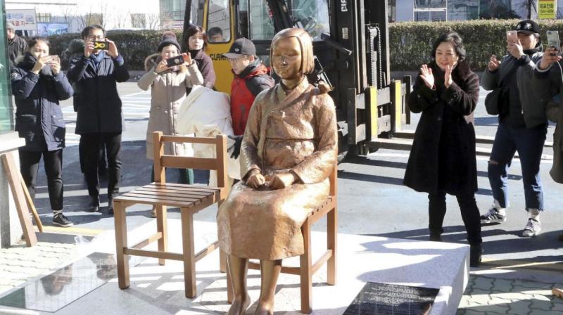 South Koreans take photos of a comfort-woman statue set up in front of the Japanese consulate in Busan, South Korea. (Photo: AP)