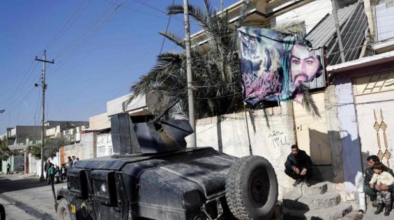 A flag bearing a portrait of Prophet Mohammeds grandson, Imam Hussein, flutters above an Iraqi Special Forces vehicle patrolling a northeastern district of the city of Mosul. (Photo: AFP)