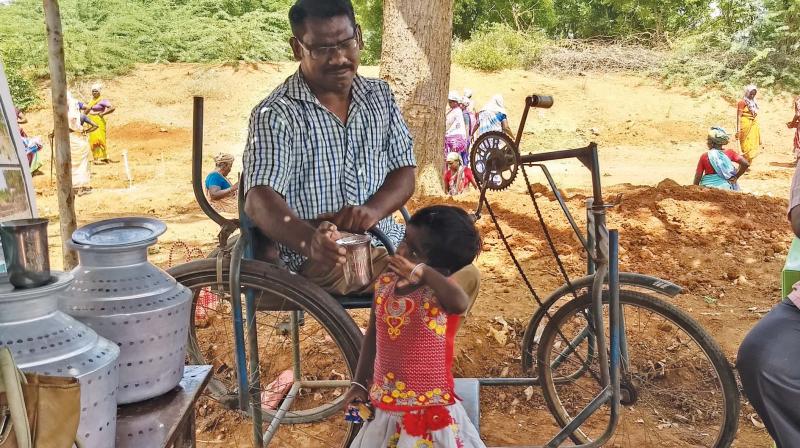 Senthilkumar, a diff-abled  person was  provided job under  MGNREGS at the worksite at Pillaiyarpatti.  He supplies drinking water to workers and their children. He maintains records also. (Photo: DC)