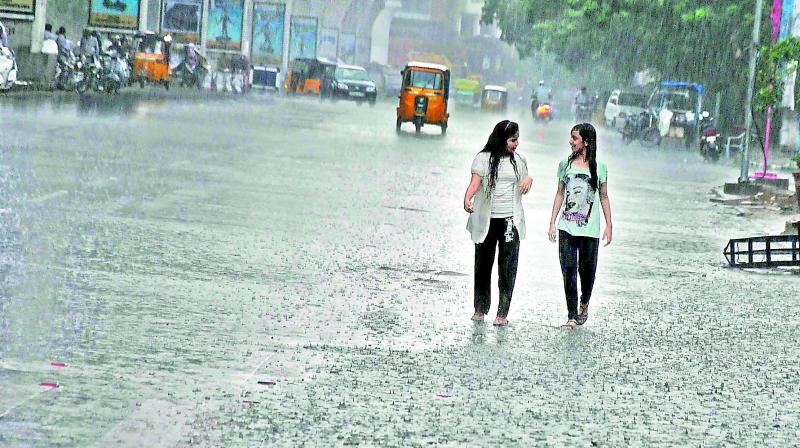 Students walk in the rain at Nampally in Hyderabad. (Photo: DC)