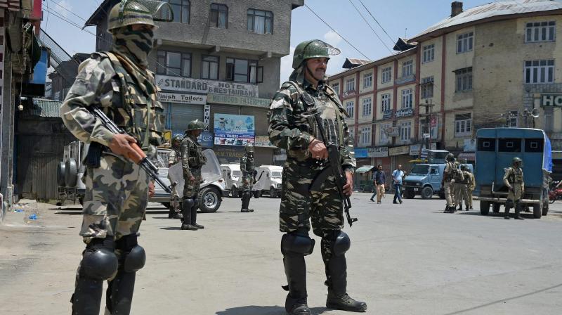 Security personnel stands guard during curfew in Srinagar on Sunday. Authorities imposed curfew in the parts of Valley following the killing of a top militant commander at Tral in Pulwama District of South Kashmir Yesterday. (Photo: PTI)