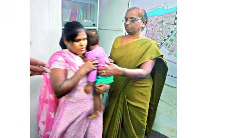 Police hand over the baby to the mother at the police station on Wednesday. (Image DC)