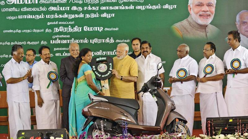 Prime Minister Narendra Modi launches the Tamil Nadu governments Amma two-wheeler scheme for working women by handing over a vehicle key to a beneficiary in Chennai on Saturday. TN Governor Banwarilal Purohit, Chief Minister Edappadi K. Palaniswami, Deputy CM O. Panneerselvam and Speaker P. Dhanapal are also seen. 	 N. Sampath