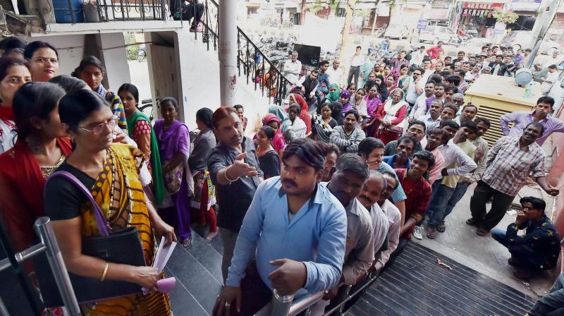 People queue up outside a bank to exchange their old Rs 1000 and 500 notes in Lucknow. (Photo: PTI)