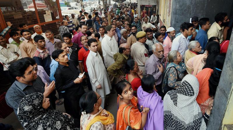 People queue outside a bank to exchange their old Rs 500 and 1000 notes in New Delhi. (Photo: PTI)