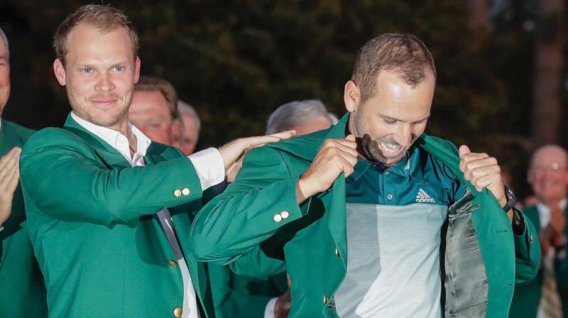 2016 champion Englands Danny Willett helps winner Sergio Garcia of Spain don the Green Jacket after the Masters golf tournament in Augusta on Sunday. (Photo: AP)