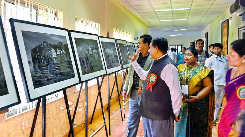 Former chief secretary Rajiv Sharma and Burra Venkatesham tourism secretary view a photo exhibition on Kakatiya sculptors on Friday. (Photo: DC)