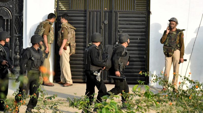 Uttar Pradesh Anti Terror Squad members take positions near a building where a suspected terrorist is holed up in the Thakurganj area of Lucknow. (Photo: PTI)