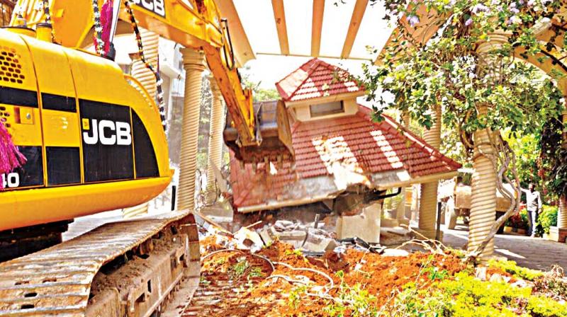 Earth movers demolishes gate of Classic Orchards on Bannerghatta Road in Bengaluru on Friday (Photo: DC)