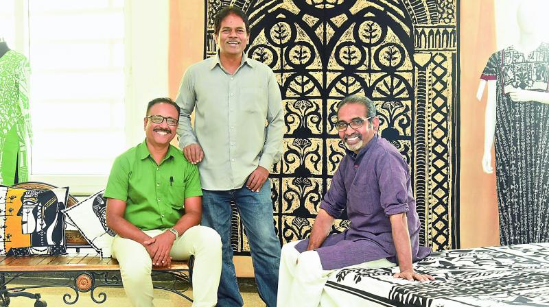 Manzoor Hussain, Sajid Bin Amar and A. Rajeswara Rao pose in front of a bedspread by Rao