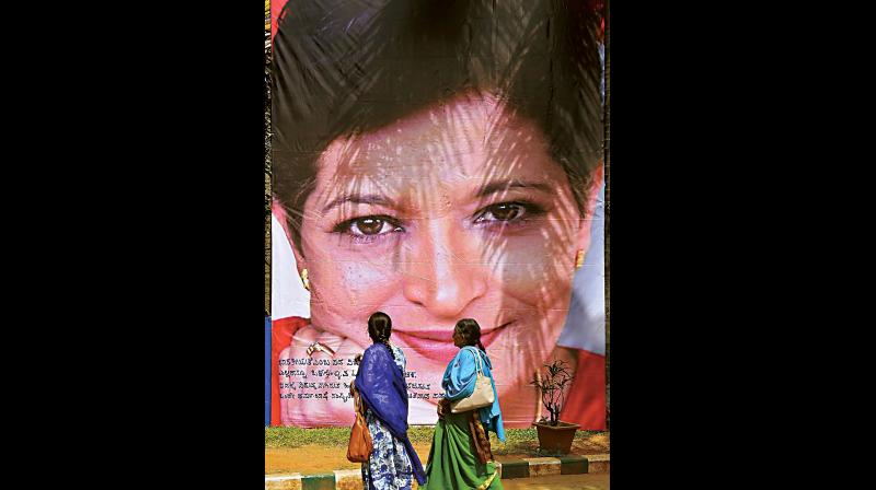 Two women walk past a poster of slain journalist Gauri Lankesh during the Freedom of Expression Meet, organised on the occasion of the first death anniversary of Gauri in Bengaluru on Wednesday. (Photo:PTI)