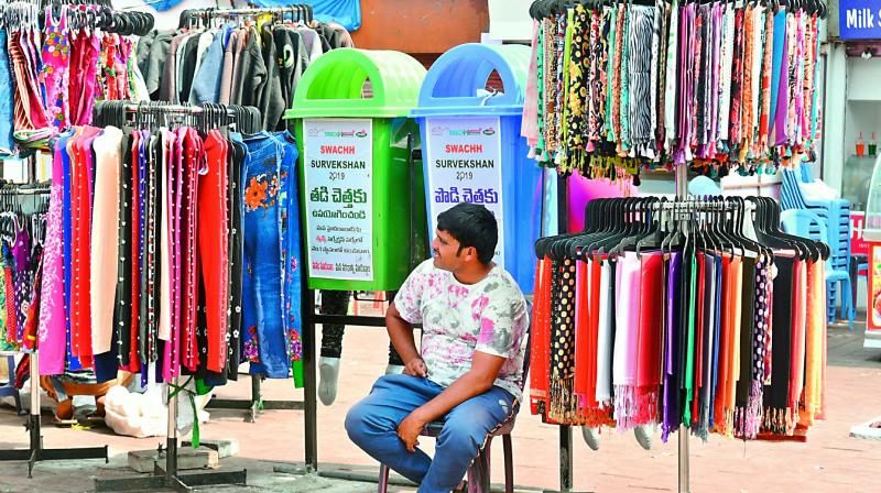 A hawker restricts access to GHMCs dustbins by setting his shop around the bins in front of the Charminar on Thursday. 	 Gandhi