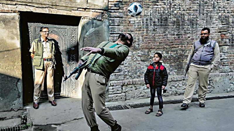 A photograph of armymen playing with children on display at Real Kashmir photo exhibition