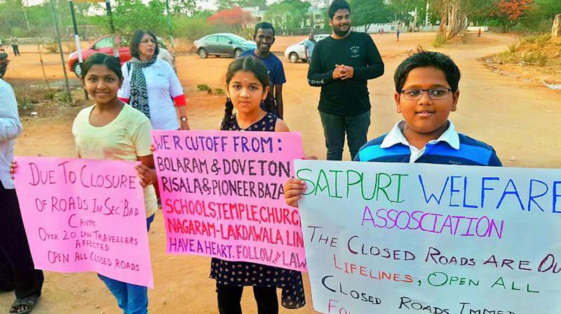 Children hold placards protesting against the Local Military Authoritys (LMA) decision to shut off roads to civilians on Saturday.  (Image: DC)